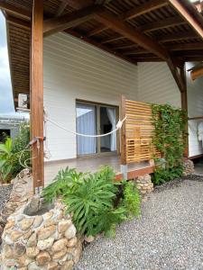 une terrasse couverte d'une maison avec un banc en bois dans l'établissement Fare noanoa, à Mariuti