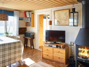 a living room with a television and a fireplace at 5 person holiday home in GREBBESTAD in Grebbestad