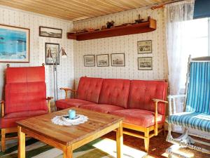 グレベスタッドにある5 person holiday home in GREBBESTADのリビングルーム(赤いソファ、コーヒーテーブル付)