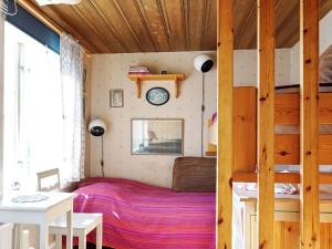 1 dormitorio con 1 cama y reloj en la pared en 5 person holiday home in GREBBESTAD en Grebbestad