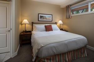 a bedroom with a bed and a lamp at Summerland Waterfront Resort & Spa in Summerland