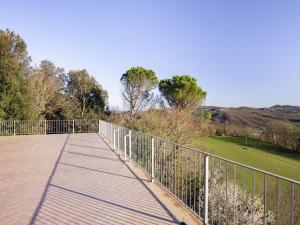 Una pasarela de madera con una valla y un campo en Belvilla by OYO Appartamento per 6, en Citerna