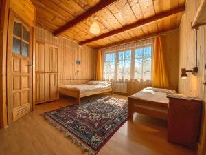 una camera con due letti e una finestra e un tappeto di Klon a Bukowina Tatrzańska