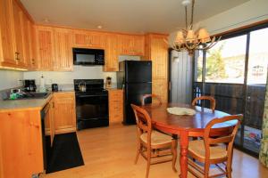 cocina con mesa de madera y nevera negra en Sierra Park Villas #23, en Mammoth Lakes