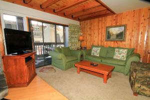sala de estar con sofá verde y TV de pantalla plana en Sierra Park Villas #23, en Mammoth Lakes