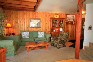 sala de estar con sofá verde y silla en Sierra Park Villas #23, en Mammoth Lakes