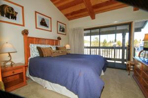 1 dormitorio con cama azul y balcón en Sierra Park Villas #23, en Mammoth Lakes