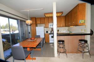 a kitchen with a wooden table and chairs and a kitchen with a counter at Sierra Park Villas #24 in Mammoth Lakes