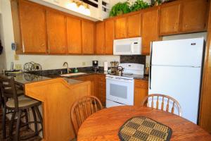 a kitchen with a white refrigerator and a table at Sierra Park Villas #88 in Mammoth Lakes