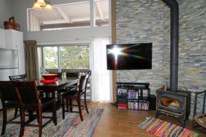 a living room with a table and a television on a brick wall at Sierra Park Villas #03 in Mammoth Lakes