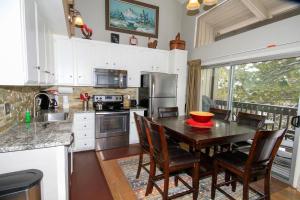 a kitchen with a wooden table and chairs and a kitchen with a sink at Sierra Park Villas #03 in Mammoth Lakes