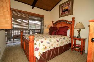 1 dormitorio con cama de madera y ventana en Sierra Park Villas #82, en Mammoth Lakes