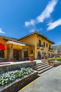 una casa amarilla con flores delante en LP Los Portales Hotel Tarma, en Tarma