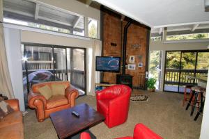 sala de estar con sillas rojas y TV en Sierra Park Villas #89 en Mammoth Lakes