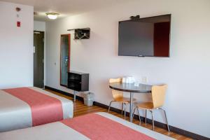 ein Hotelzimmer mit einem Bett, einem Tisch und einem TV in der Unterkunft Motel 6-Lincoln, NE in Lincoln