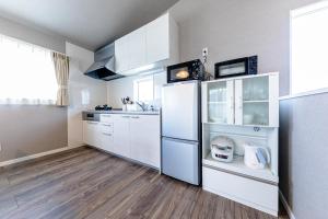 a kitchen with white cabinets and a refrigerator at Bon Moment A棟-紅葉館 in Fujikawaguchiko