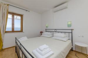 Un dormitorio con una cama con toallas blancas. en Apartments Lemar - with parking, en Bol