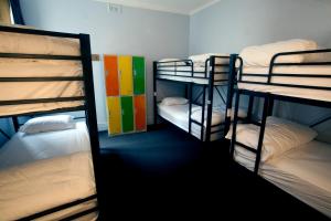 a room with four bunk beds in a dorm room at Backpackers Imperial Hotel in Hobart