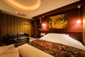 a hotel room with a bed and a couch at Hotel CUE Machida(Adult Only) in Machida