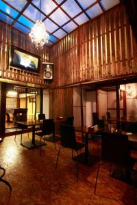 a dining room with tables and chairs and a tv at Kyoto G in Kyoto