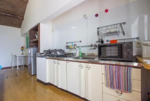 a kitchen with white cabinets and a microwave at Kyoto G in Kyoto