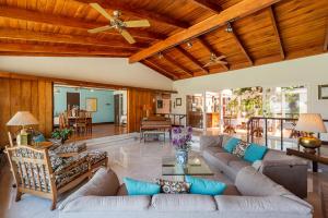 una sala de estar de planta abierta con sofás y techo de madera. en Posada el Quijote, en San José