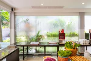 a kitchen with a large window with plants in it at FuramaXclusive Sathorn, Bangkok in Bangkok