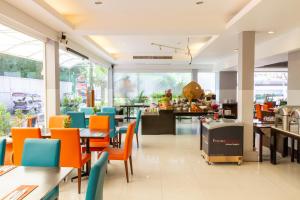 a restaurant with orange and blue chairs and tables at FuramaXclusive Sathorn, Bangkok in Bangkok