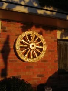 a gold clock on the side of a brick wall at Ulster Lodge Motel in Hamilton