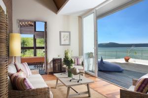 a living room with a view of the ocean at Plataran Menjangan Resort and Spa - CHSE Certified in Banyuwedang