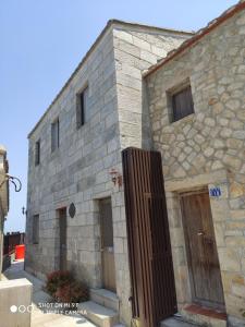 un edificio in pietra con un cancello di fronte di 芹壁溫馨海景民宿 a Beigan