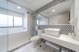 a bathroom with a toilet and a sink and a shower at Fish Hotel Hualien in Hualien City