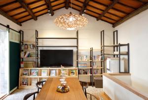 a dining room with a table and a television at My Way House 好巷一弄民宿 in Tainan