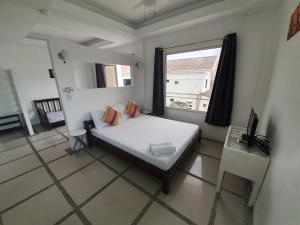 a small bedroom with a bed and a window at ClubBoracay Apartelle in Boracay
