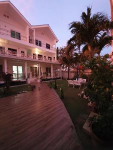 a building with a wooden walkway in front of a yard at ClubBoracay Apartelle in Boracay