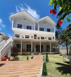 a large white house with a wooden deck at ClubBoracay Apartelle in Boracay
