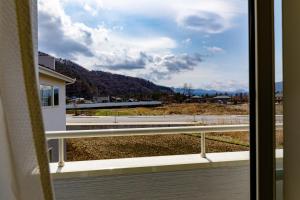 een raam met uitzicht op de bergen bij Bon Moment B棟-桜館 in Fujikawaguchiko