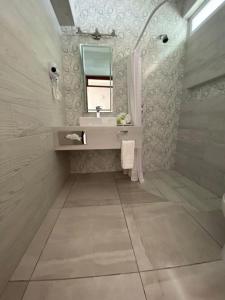 uma casa de banho com um lavatório e um espelho em Hotel Posada Quinta Las Flores em Cuernavaca