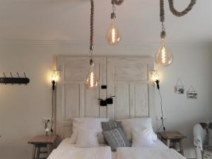Un dormitorio con una cama blanca con luces encima. en Zur Mühle, en Bad Birnbach