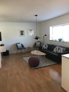 a living room with a black couch and a table at Skagen New City Apartments 1D in Skagen