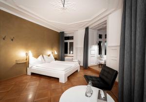 ein Schlafzimmer mit einem weißen Bett und einem schwarzen Stuhl in der Unterkunft Gasthaus zum Guten Glück in Zürich