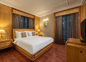 a bedroom with a large bed and a television at Sarovar Portico Kalupur Ahmedabad in Ahmedabad