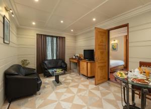 a living room with a couch chair and a television at Sarovar Portico Kalupur Ahmedabad in Ahmedabad