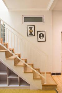 eine Treppe in einem Haus mit zwei Bildern an der Wand in der Unterkunft Huning House - 5 Bedrooms in Purwokerto