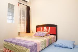 una camera con letto e finestra di Huning House - 5 Bedrooms a Purwokerto