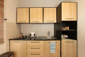 a kitchen with wooden cabinets and a sink at Huning House - 5 Bedrooms in Purwokerto