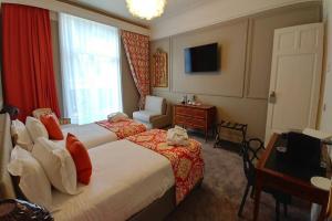 a hotel room with two beds and a television at Grand Hotel Bellevue - Grand Place in Lille