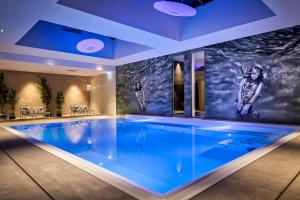 a swimming pool in a house with a painting on the wall at Van der Valk Hotel Tilburg in Tilburg