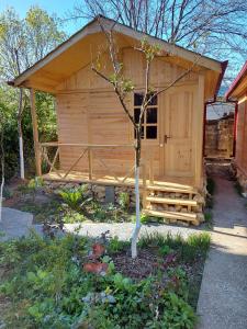 a small wooden cabin with a porch in a garden at Old City Hotel in Kutaisi