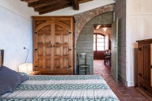 Un dormitorio con una cama y una puerta de madera. en La Casina- Podere della Collina, en Collelungo 9 fotos más